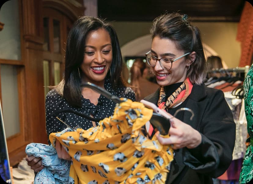 Two women smiling while shopping in a boutique