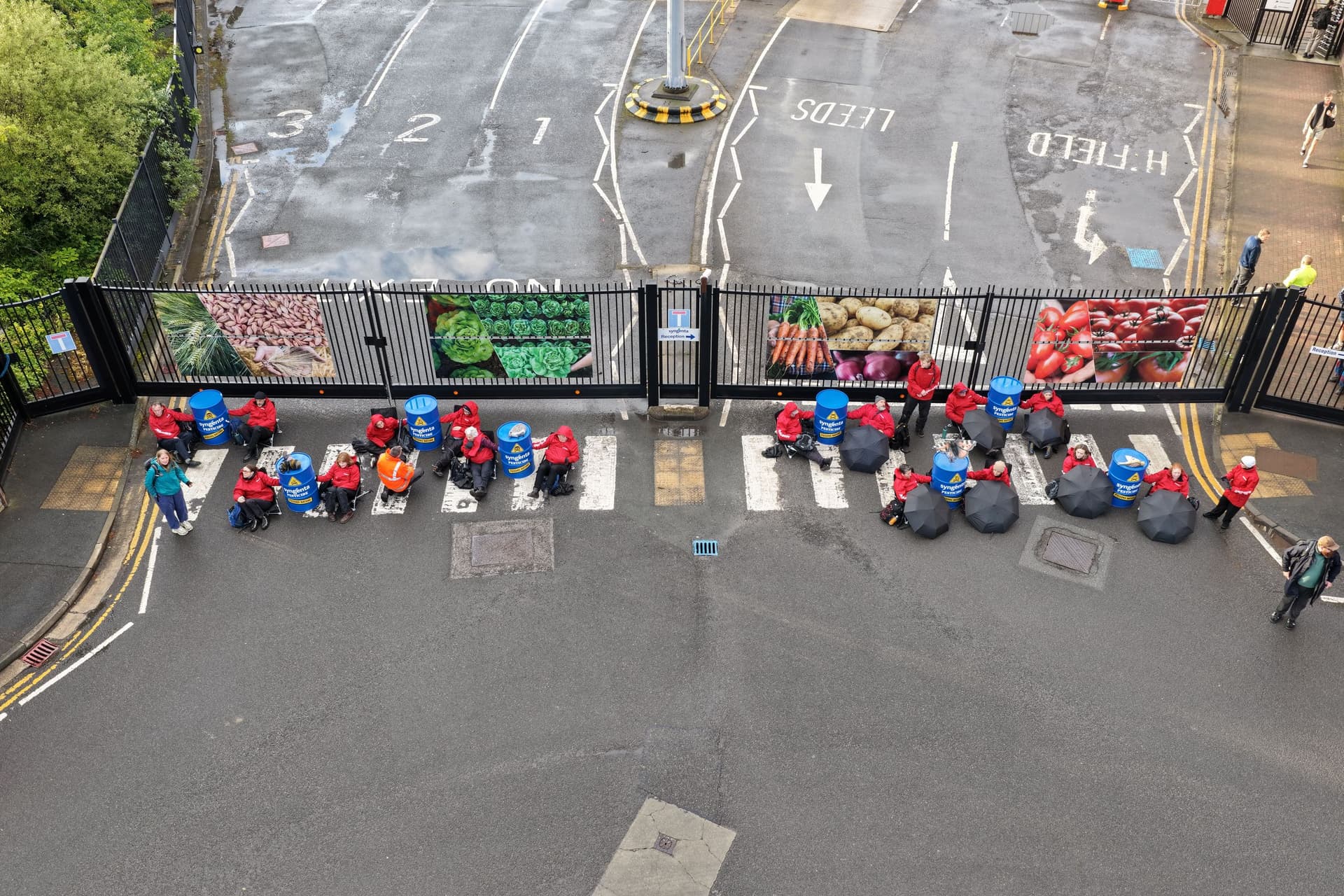 Group of people in red jackets on mobility scooters near gate
