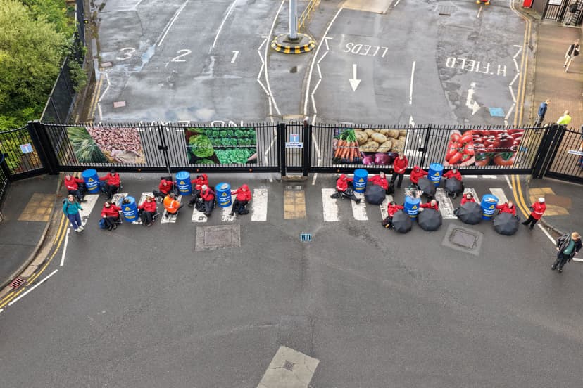 Group of people in red jackets on mobility scooters near gate