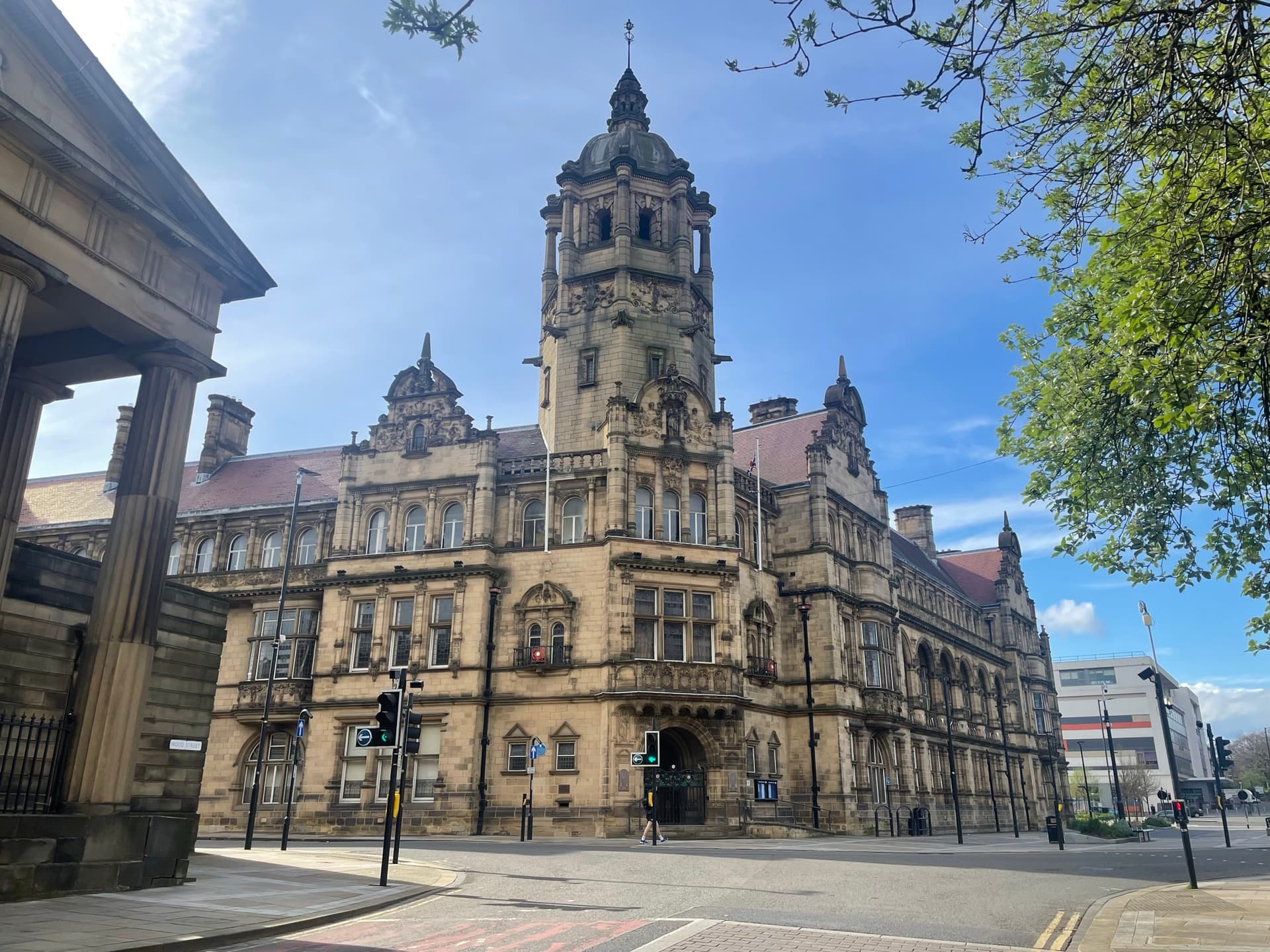Victorian town hall with ornate clock tower under blue sky