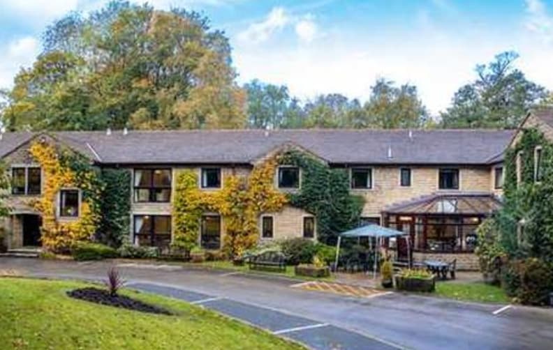 Charming stone hotel with ivy-covered walls in lush garden