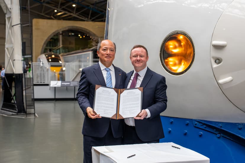 Two men holding a signed document at a railway museum