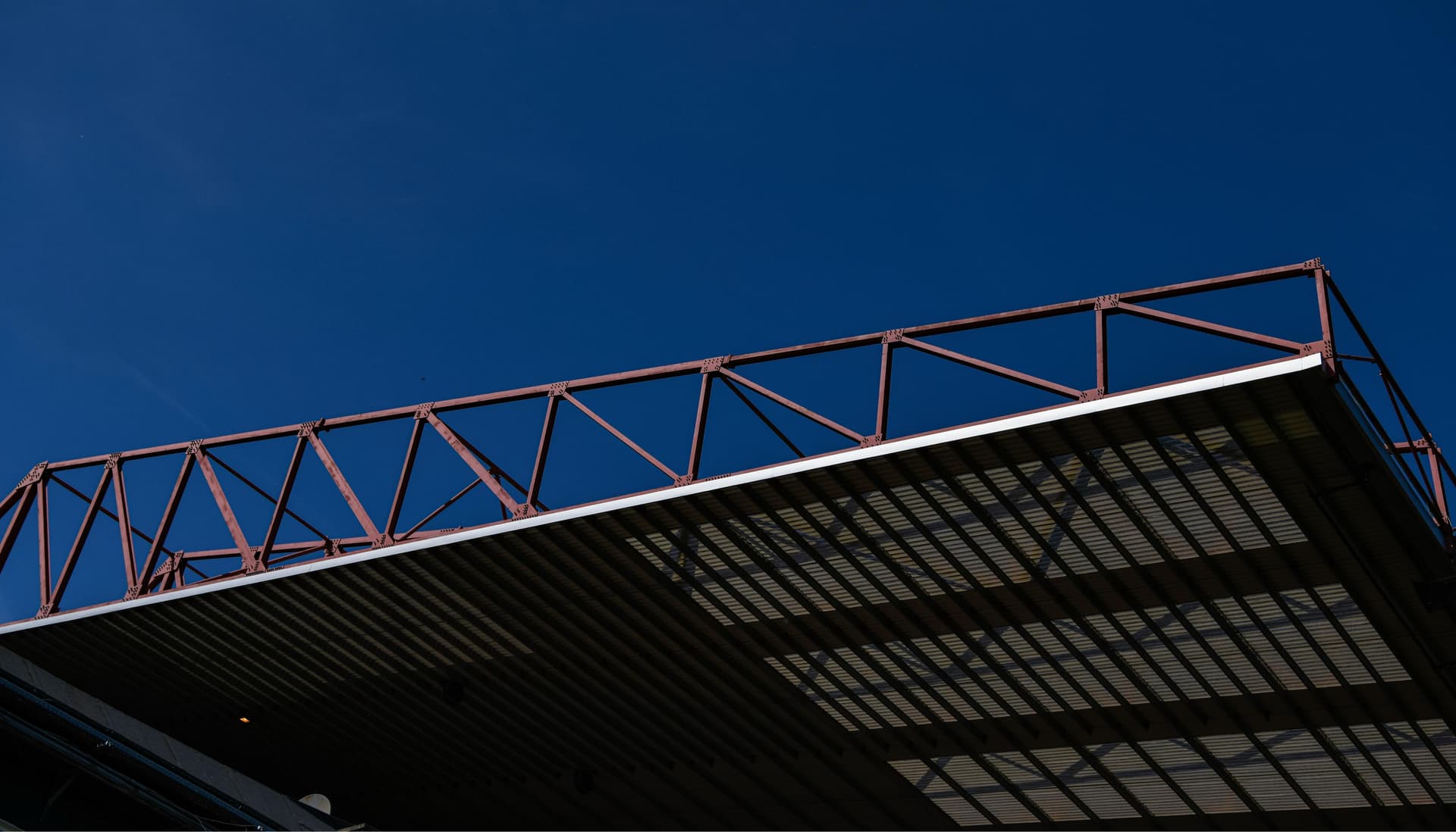 Industrial steel roof structure against clear blue sky