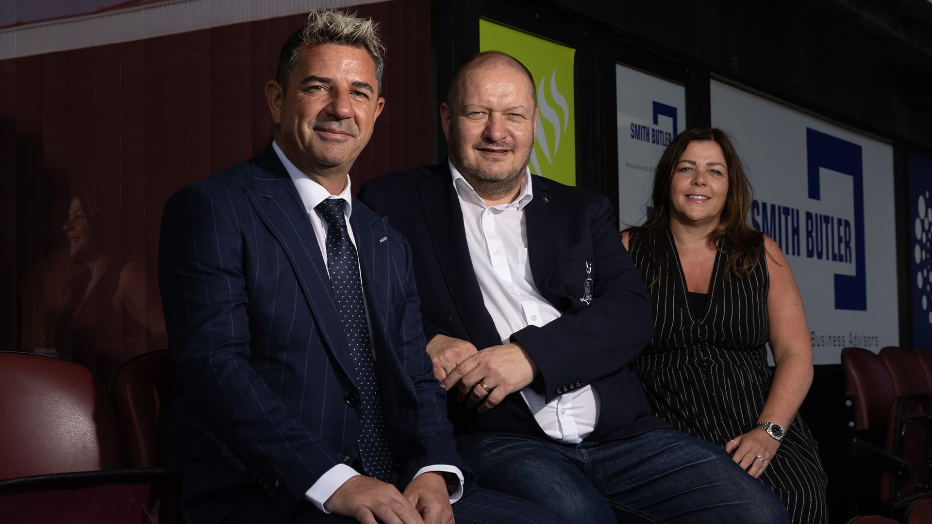 Three people sitting in a business conference setting