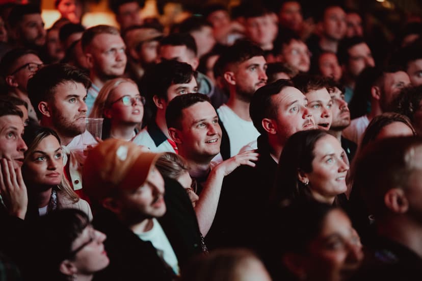 Crowd of people watching an event with focused expressions