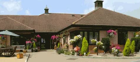 Charming cottage with floral displays and patio seating