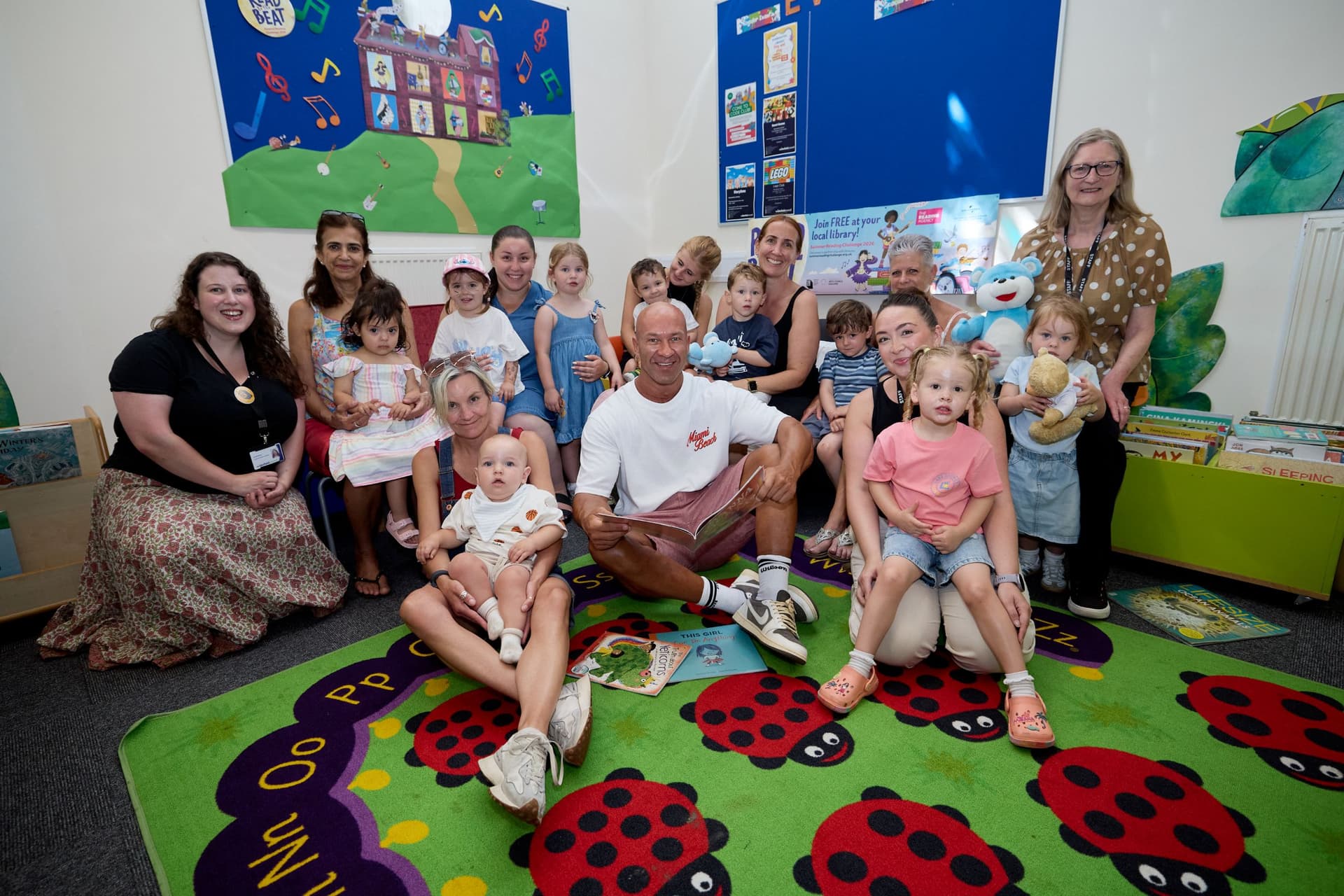 Group of adults and children in a colorful classroom setting