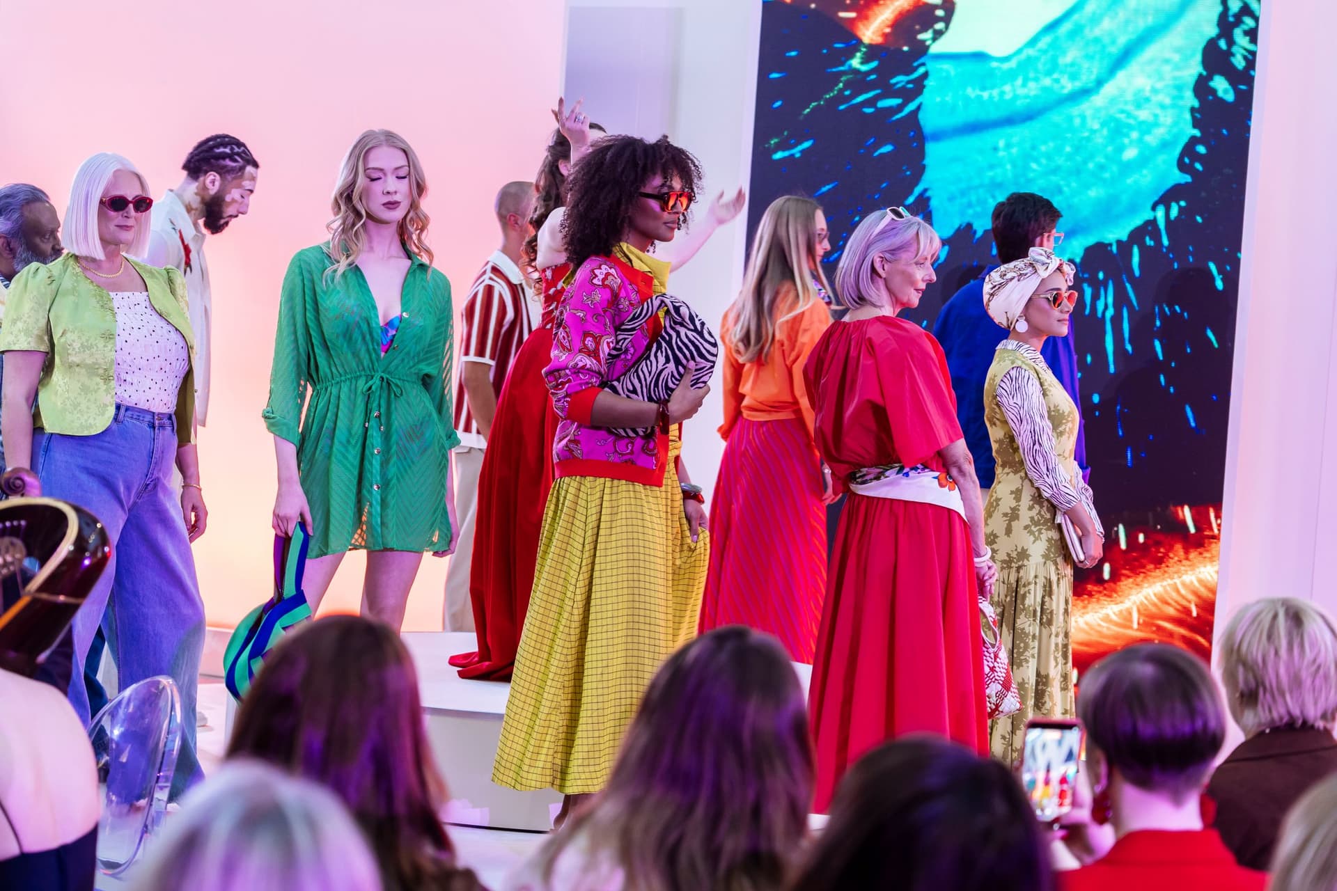 Diverse models in vibrant outfits on fashion runway