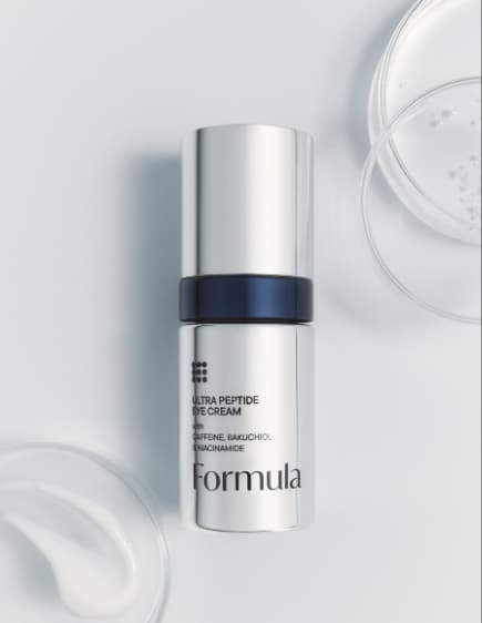 Silver skincare bottle with black accent on white surface