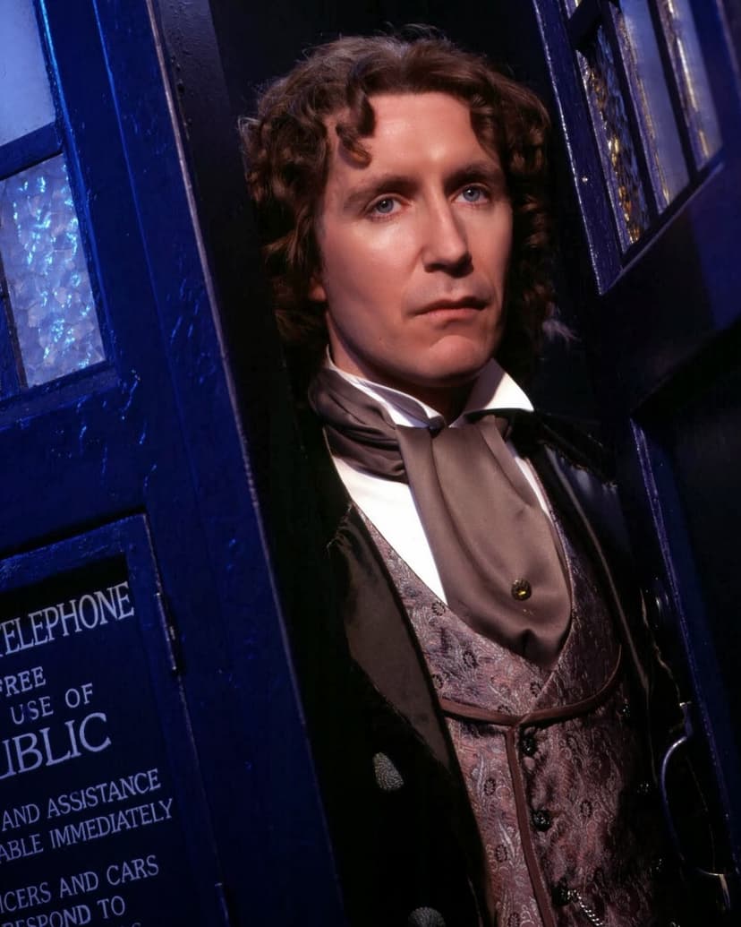 A man with curly hair in Victorian attire stands in the doorway of a blue police box, evoking a sci-fi atmosphere.