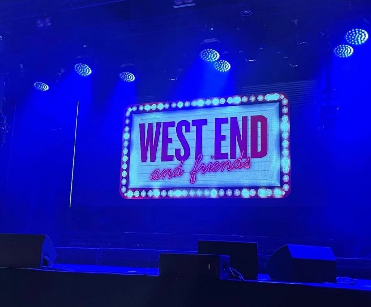 Illuminated theater stage with West End and Friends sign