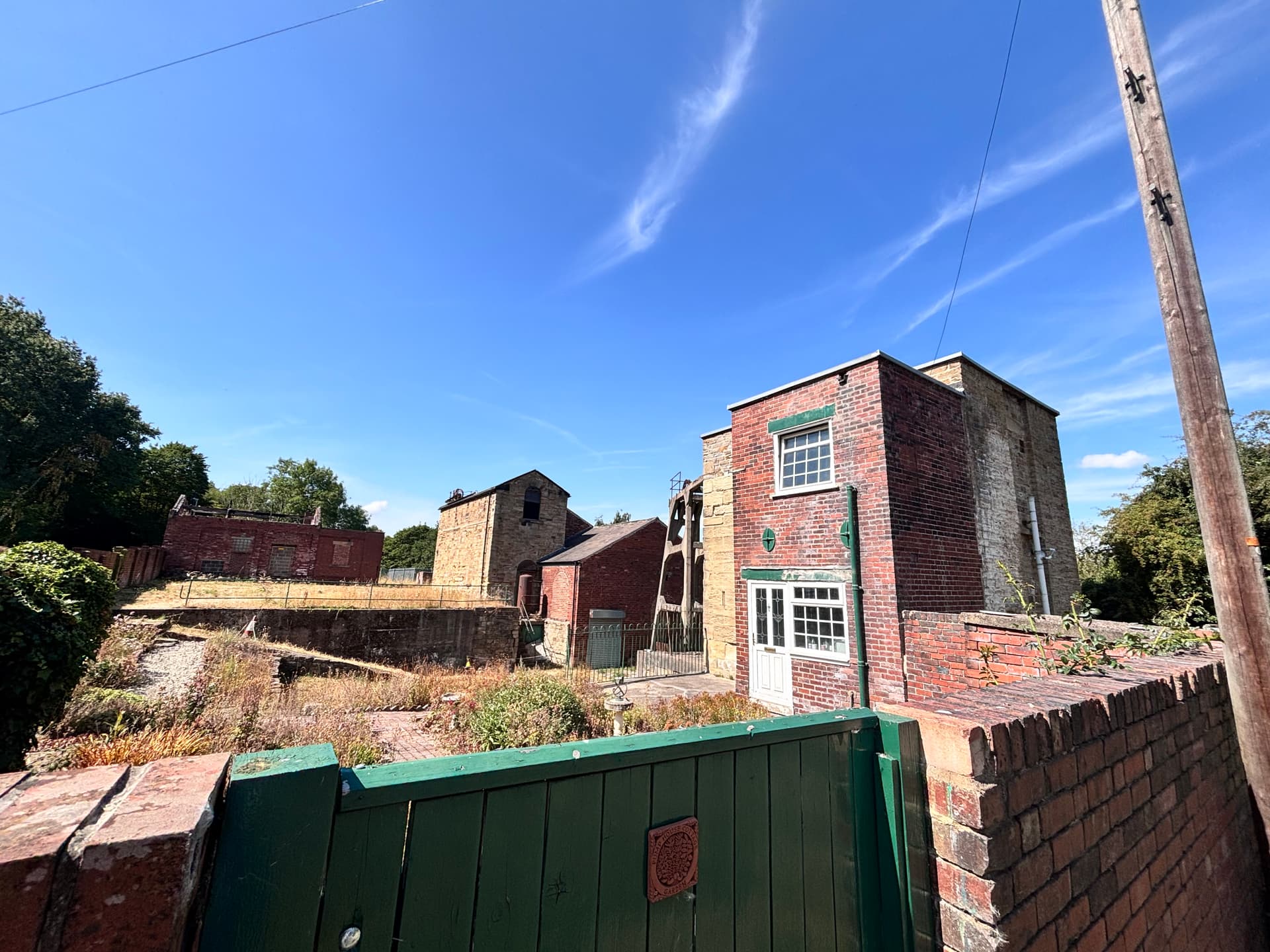 Historic red brick buildings with green gate under blue sky