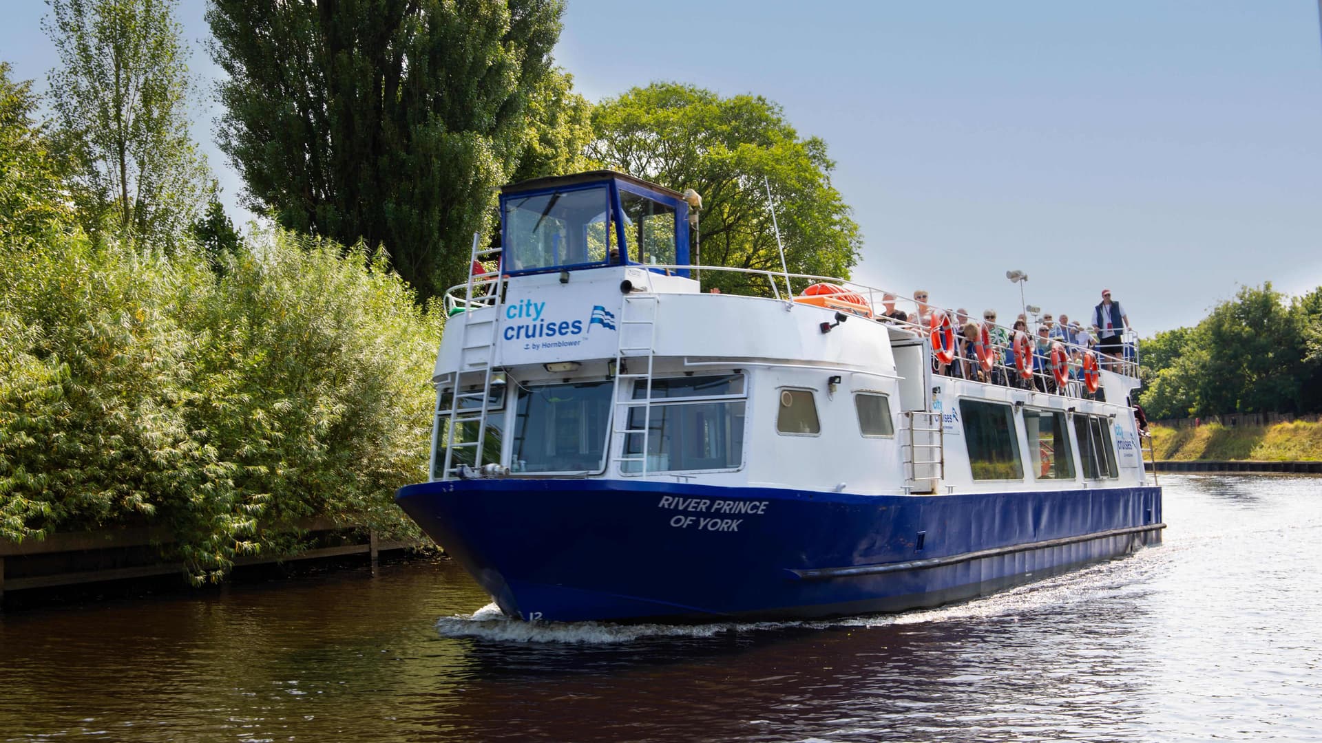 Tour boat with passengers cruising on River Ouse in York