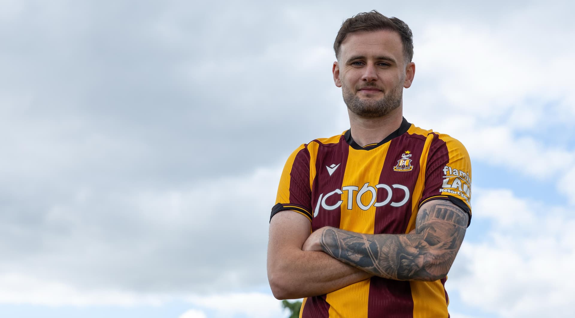 Man in Bradford City football jersey standing outdoors