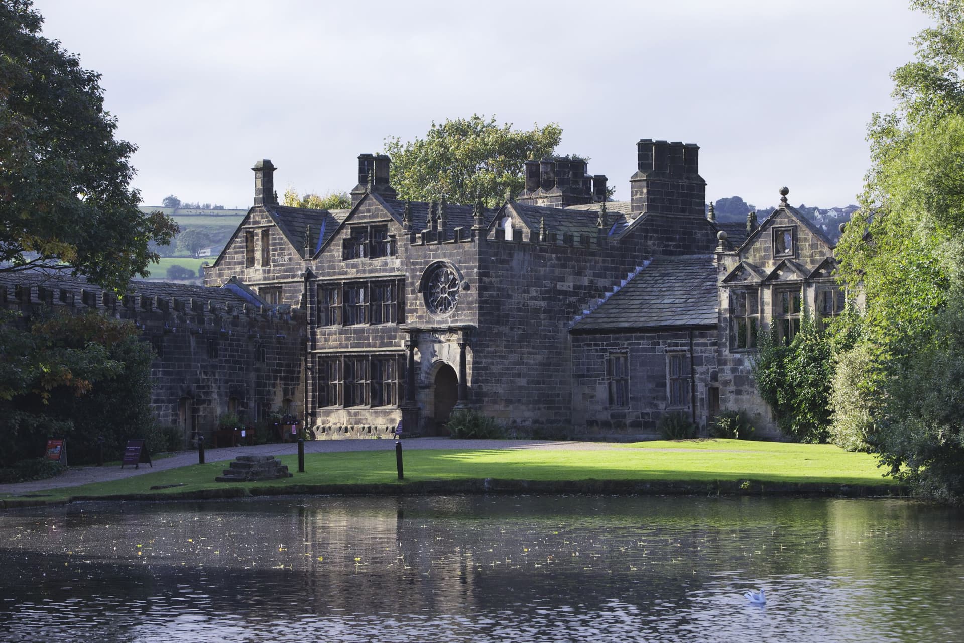 Historic stone manor house with turrets by a tranquil lake