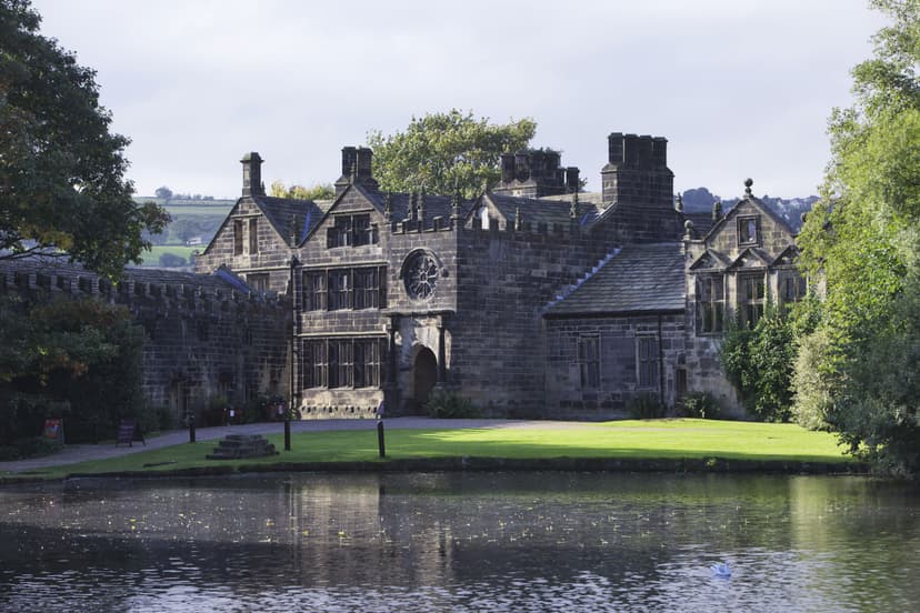 Historic stone manor house with turrets by a tranquil lake