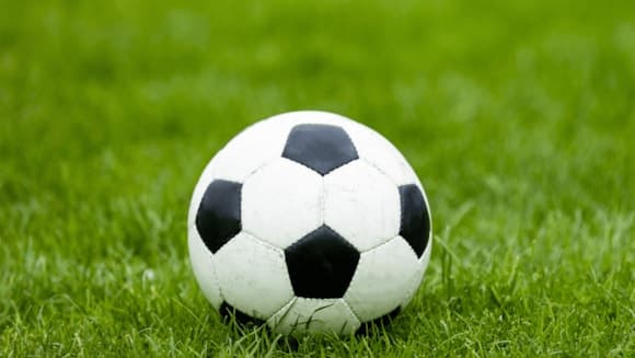 Traditional black and white football on lush green grass