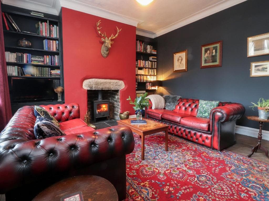 Heathcliff Cottage in Haworth with red leather sofas and antler decor