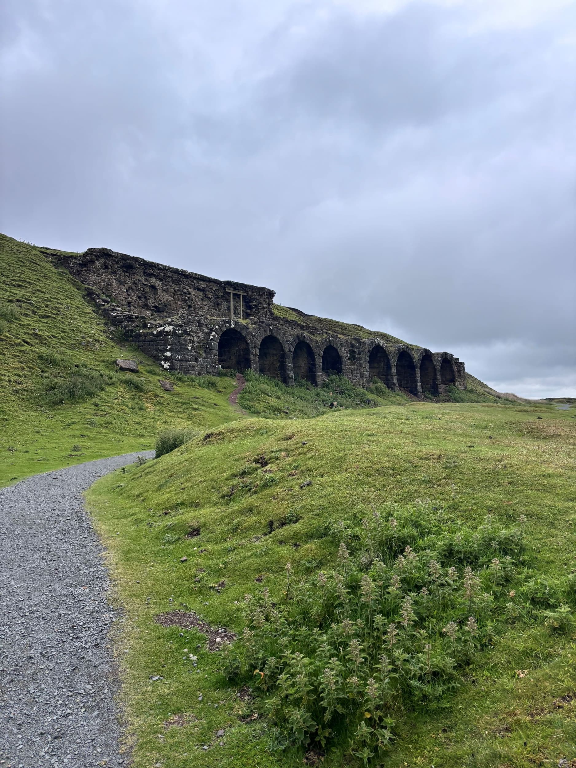 Historic stone viaduct arches set in lush green hills