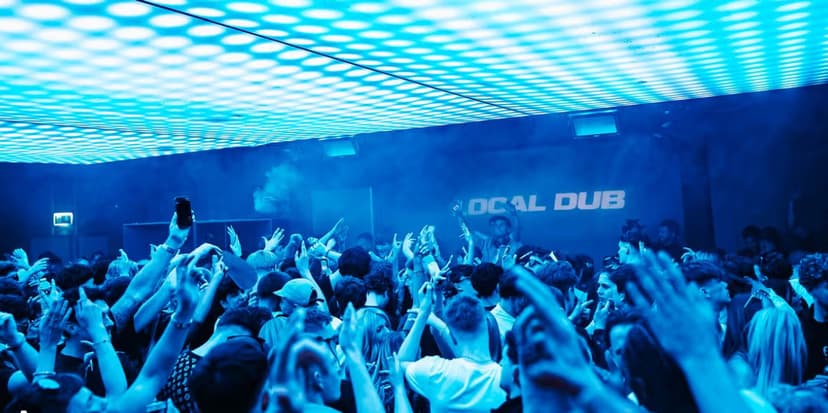 Vibrant nightclub scene with people dancing under blue lights
