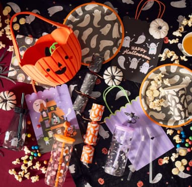Halloween-themed table setting with ghost plates and pumpkin decor