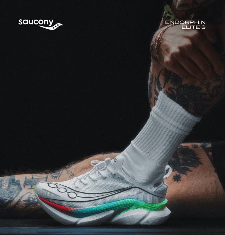 Tattooed legs wearing white running shoes with colorful sole