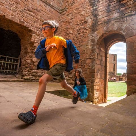 Children playing in a medieval stone castle courtyard