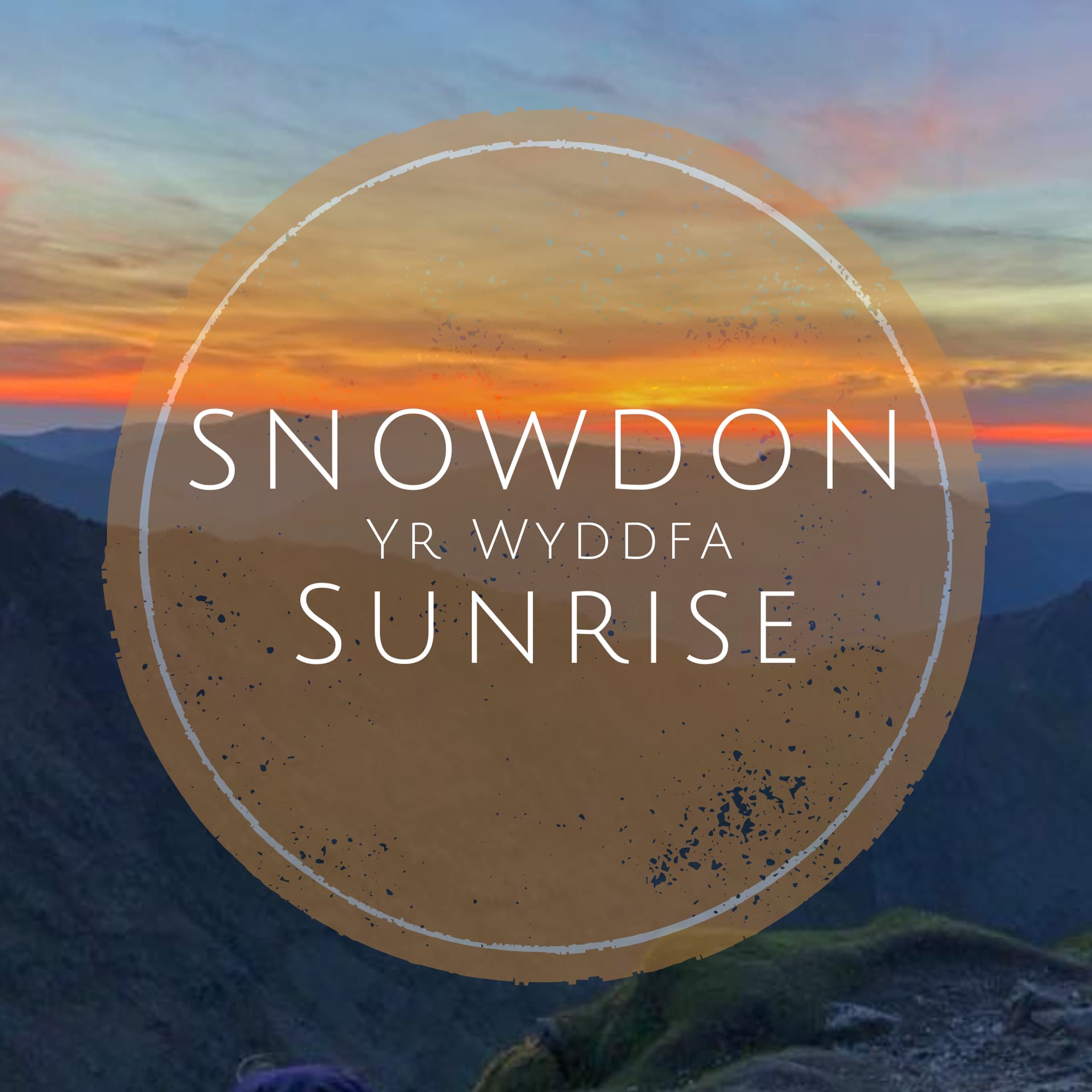 Stunning sunrise over Snowdon, casting vibrant colors across the mountainous landscape, creating a serene atmosphere.