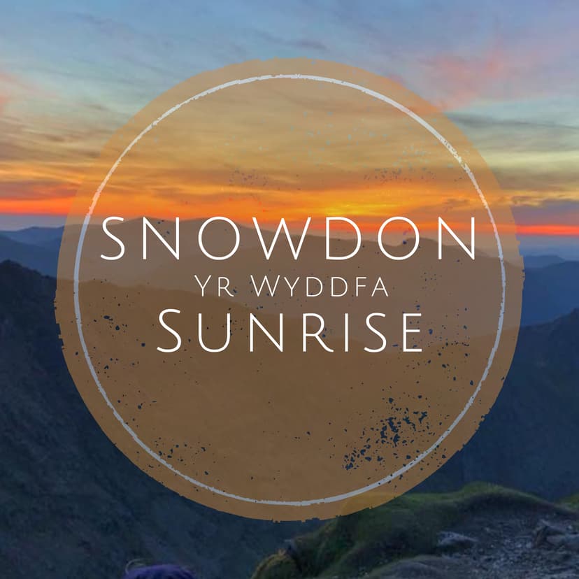 Stunning sunrise over Snowdon, casting vibrant colors across the mountainous landscape, creating a serene atmosphere.
