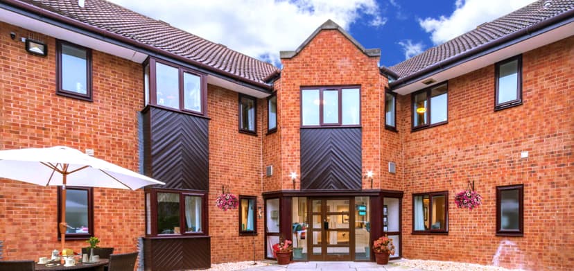 Modern brick building with pitched roofs and patio umbrellas