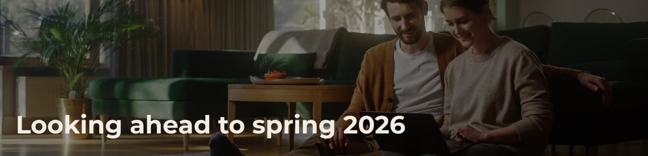 Couple sitting together on floor looking at tablet in cozy living room