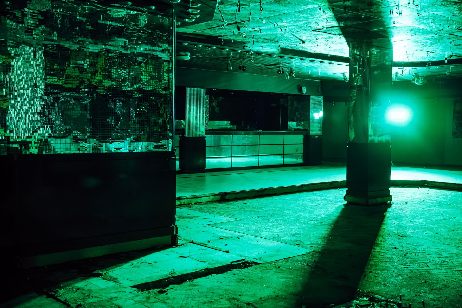 Dimly lit nightclub interior with green lighting