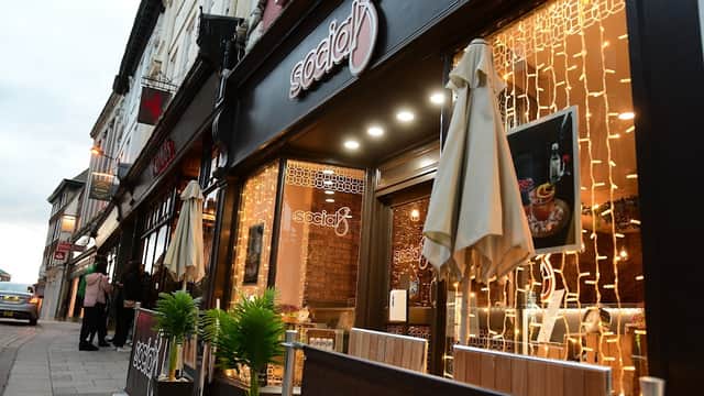 Cozy pub entrance with warm lighting, outdoor seating, and decorative plants in York, Yorkshire.
