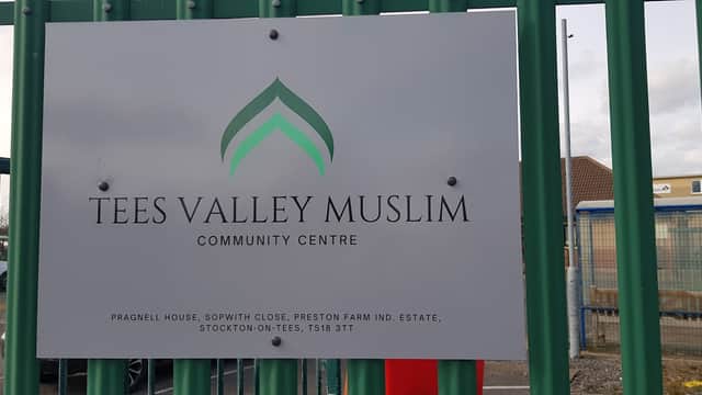 Sign for Tees Valley Muslim Community Centre, featuring green and white logo on a metal fence.