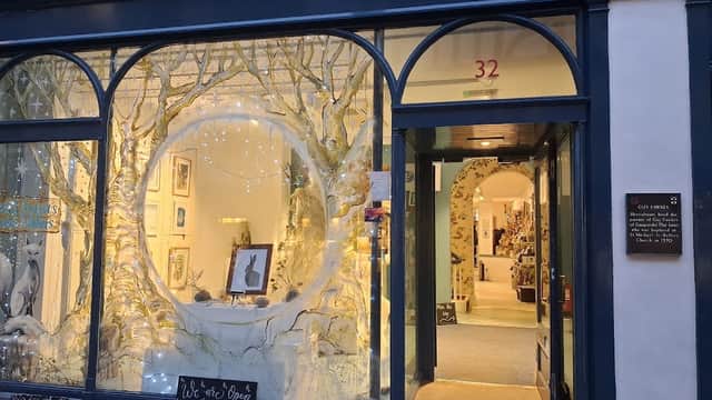 Charming storefront with arched windows, featuring artistic displays and a welcoming entrance in York, Yorkshire.