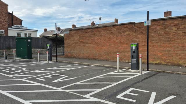 Electric vehicle charging stations in a car park with a brick wall backdrop in Marske, Yorkshire.