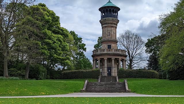 Victorian tower surrounded by lush green grass and trees under a cloudy sky at Locke Park, Barnsley.