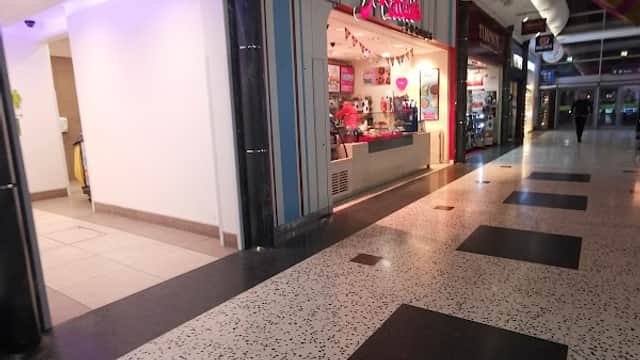 Millies Cookies shop with colorful signage in a shopping mall, featuring a bright interior and tiled flooring.