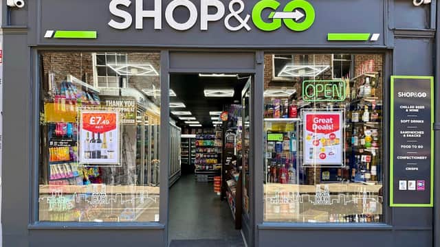 Bright storefront of SHOP & GO with open sign, displaying drinks, snacks, and promotional posters in York.
