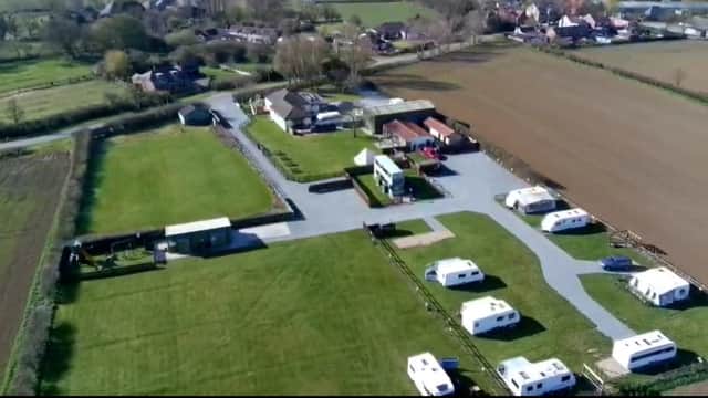 Aerial view of Hollym Holiday Park featuring caravans, green fields, and surrounding residential areas in Holmpton, Yorkshire.