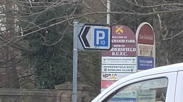 Signage indicating free parking at Water Street Car Park, with nearby club and park information in Huddersfield, Yorkshire.