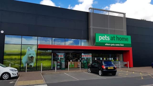 Storefront of Pets at Home in Leeds, featuring a large sign, green accents, and a dog image on the window.