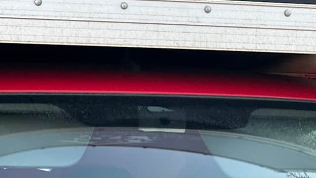 Red van with "TT Removals" sign and contact information, parked in a car park with trees in the background.