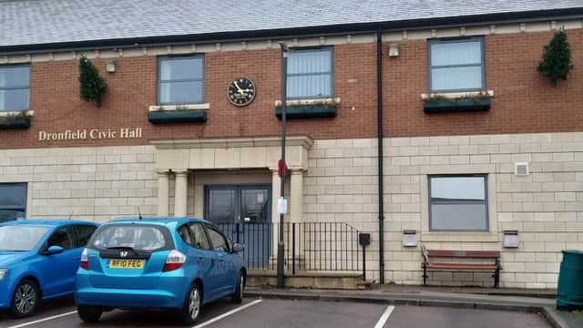 Dronfield Civic Hall with a clock, parking spaces, and a blue car in front. Greenhill, Yorkshire. Free parking sign visible.