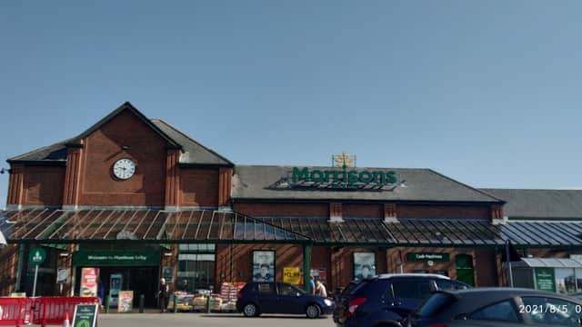Morrisons store in Selby, Yorkshire, featuring a clock tower and large glass entrance with shopping carts outside.