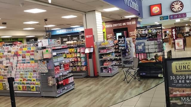 WHSmith store interior featuring books, cards, and a Costa Coffee counter in a motorway service area.