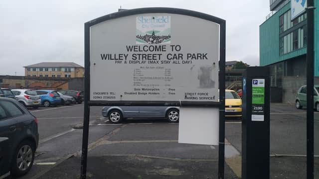 Welcome sign for Willey Street Car Park, with parking spaces and nearby buildings in Sheffield.