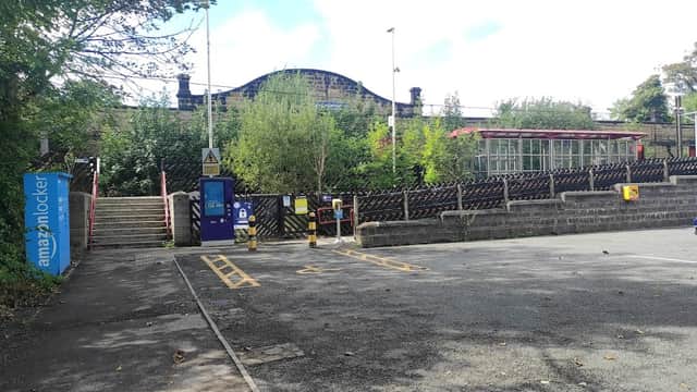 Frizinghall Station Car Park with parking spaces, greenery, and steps leading to the station entrance.