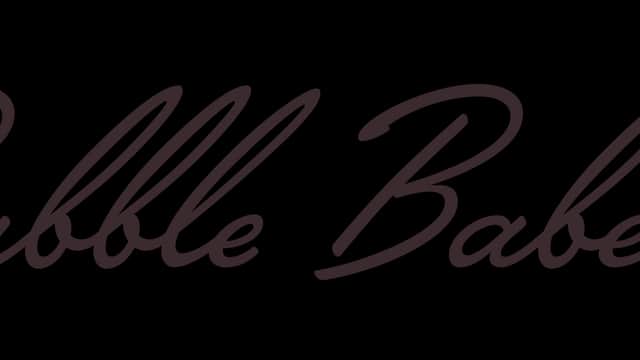 "Bubble Babes Launderette sign with playful, cursive lettering on a dark background."