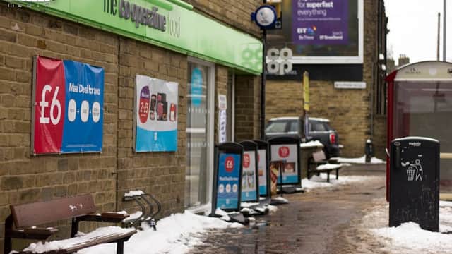 Co-op Food storefront in Wibsey, Yorkshire, with benches, snow, and promotional signs visible.